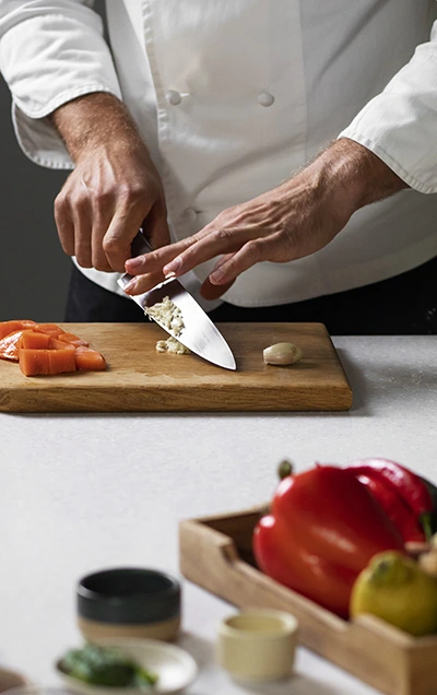 Cuisinier en train de couper des légumes.