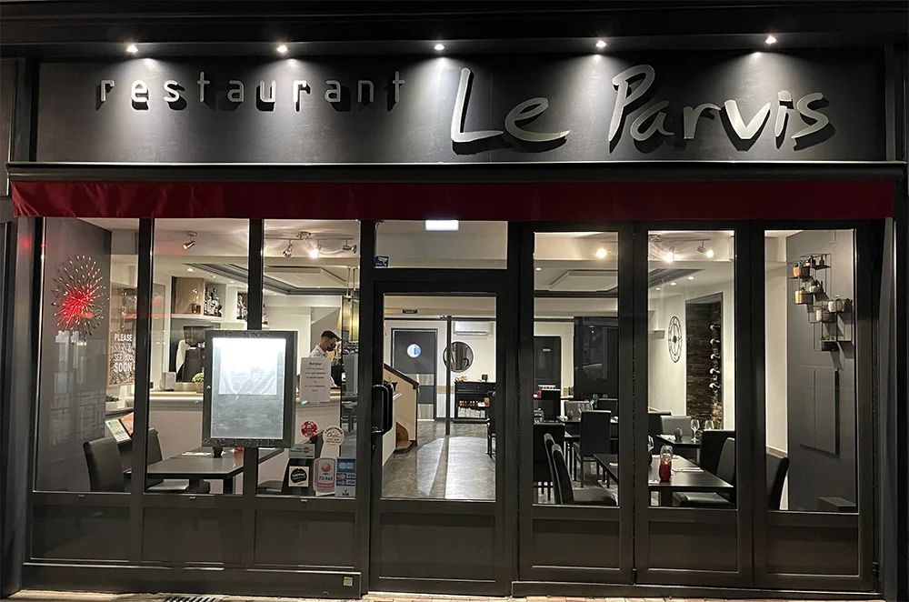 Façade du restaurant Le Parvis à Cholet vue de nuit.