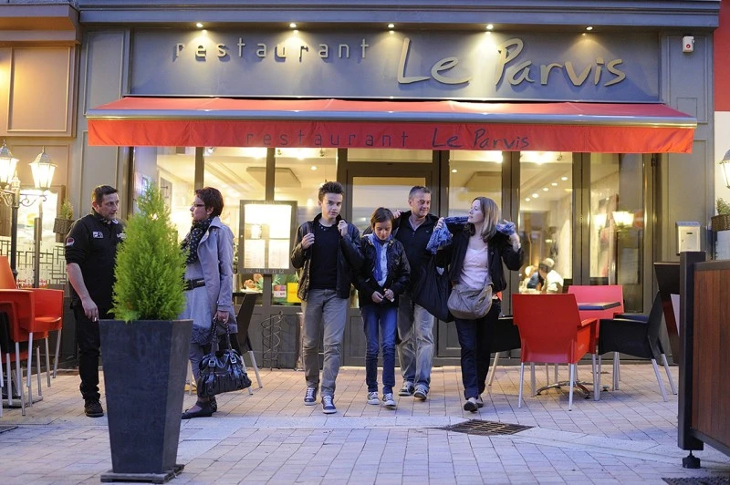 Vue extérieure du restaurant Façade du restaurant avec des personnes devant l’établissement.